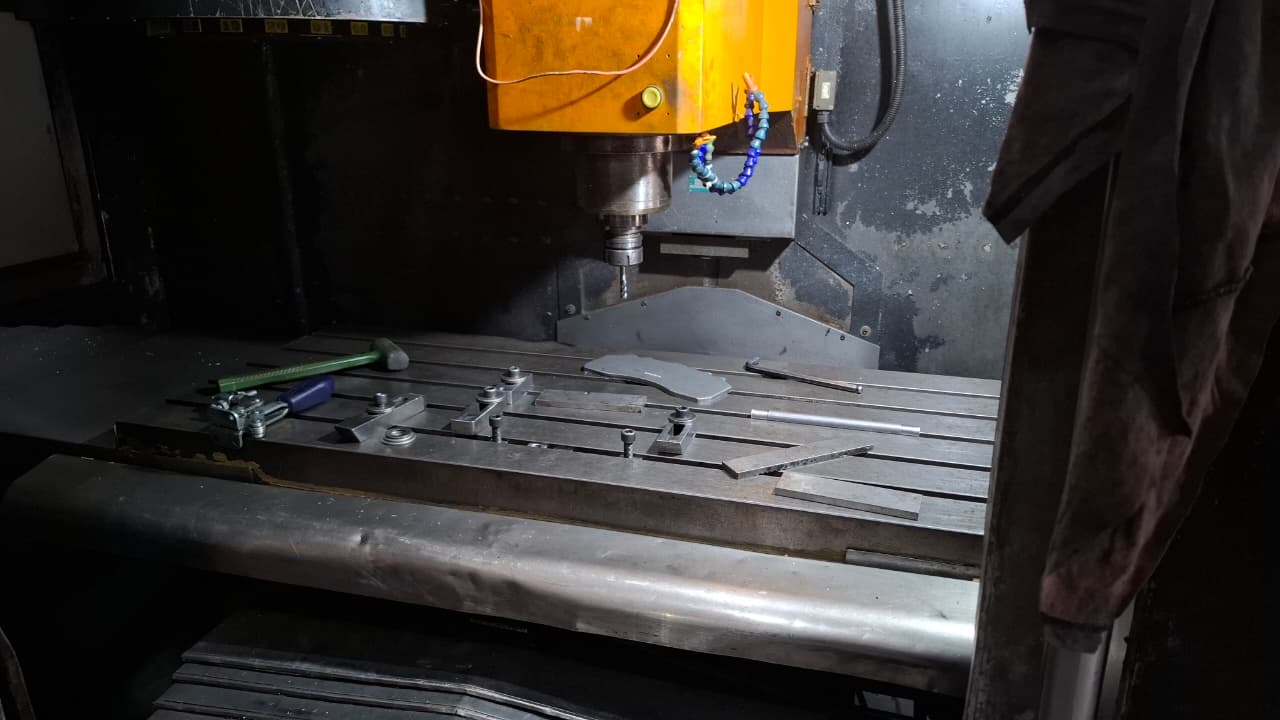 Centro de usinagem CNC industrial moderno com carenagem preta e painel de controle laranja em ambiente de fábrica